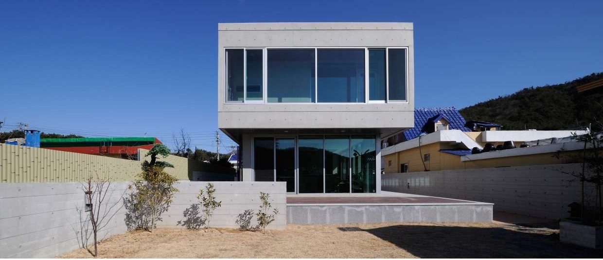 Completed concrete house with a projecting glazed corner window