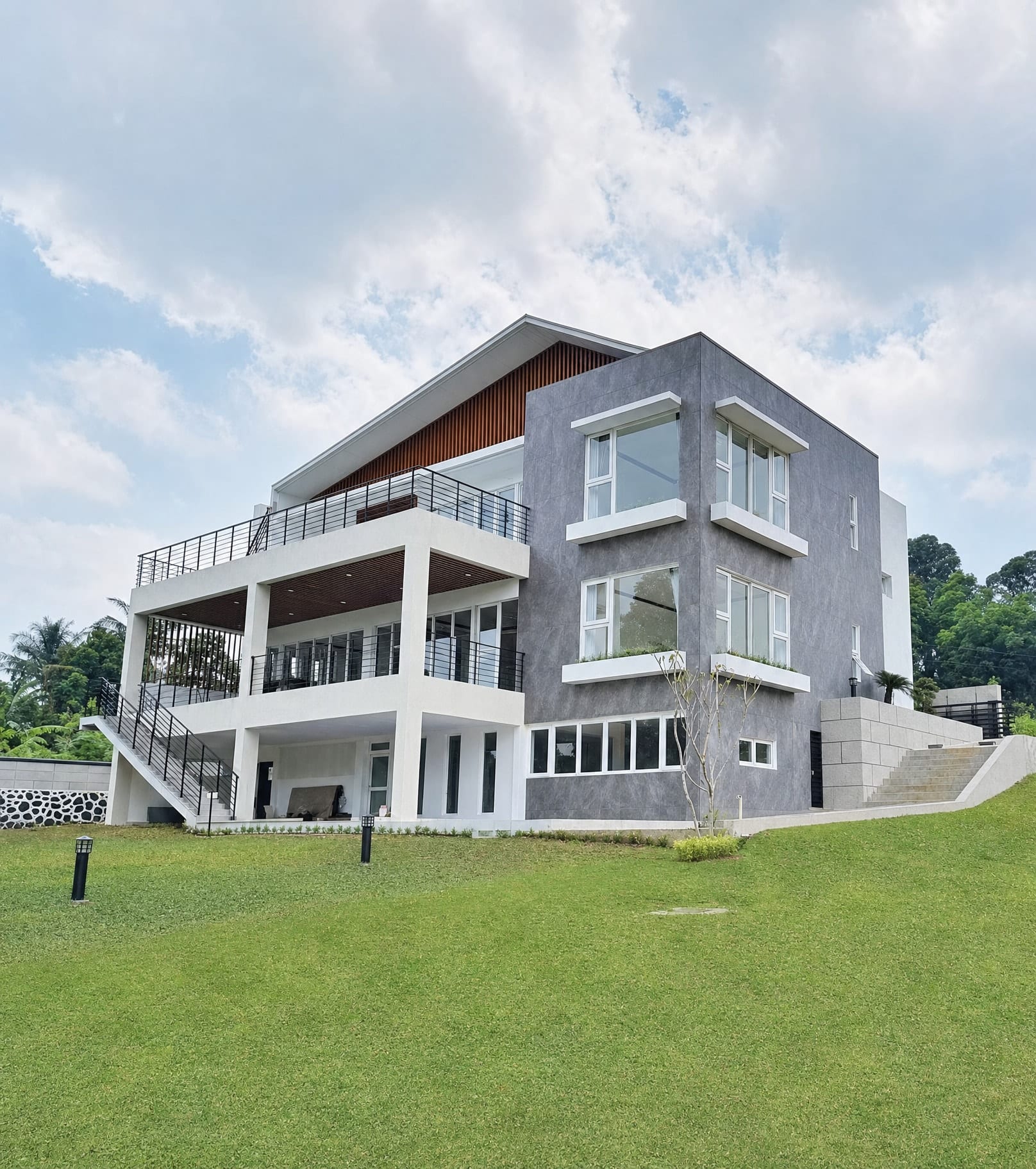 Completed stone-clad house with a gabled roof and covered terrace