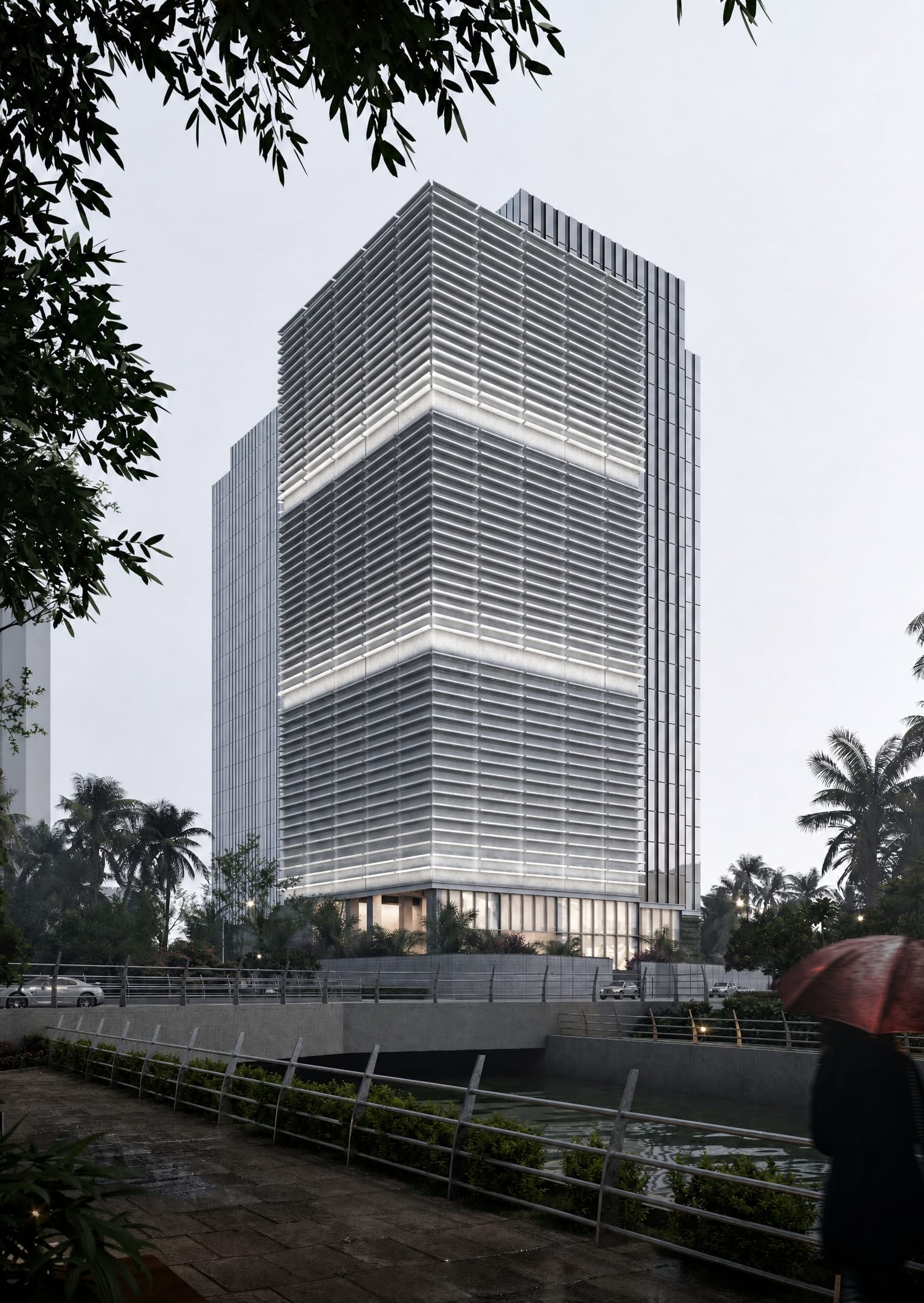 Louvred office tower beside a riverside walkway at dusk